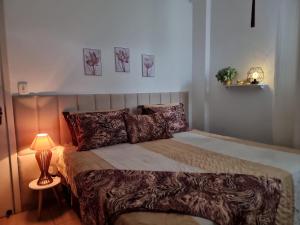 a bedroom with a bed with a lamp and pictures on the wall at Ape da Deisi Termas in Gravatal +48 photos