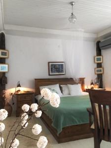 Gokceada Town的住宿－Dimitri Ada Evi & Restaurant，一间卧室配有一张带绿色棉被的床