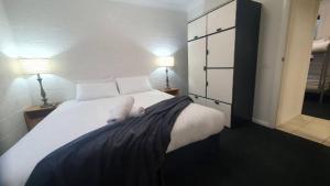 a bedroom with a large white bed with two lamps at Southern Cross Apartment 1 in Falls Creek