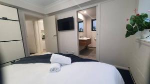 a bedroom with a white bed and a television at Southern Cross Apartment 1 in Falls Creek +1 photo