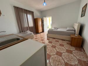 a bedroom with a bed and a kitchen with a sink at Vila 23 in Dhërmi +19 photos