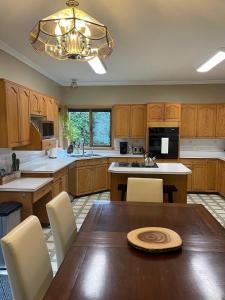 a kitchen with wooden cabinets and a wooden table at The HI-Mark House - Hot tub,AC,Pool table, Pool May2026 in Sicamous