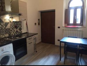 a kitchen with a stove and a table with chairs at La Casa di Gioia in Tuscania