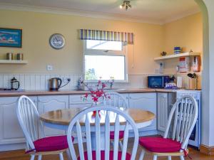 a kitchen with a table and chairs in a kitchen at Treyarnon in St Merryn