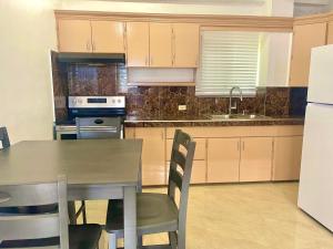 a kitchen with a table and chairs and a refrigerator at Pedros Heights 2 Bedroom & 1 Bathroom in Tumon