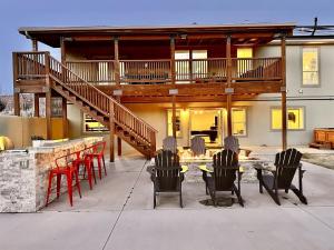 a house with a patio with chairs and a table at Exclusive Retreats Desert Dream Estate 8 Bedrooms in Moab