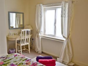une chambre avec un lit, une fenêtre et une table dans l'établissement Riverbank Cottage, à Althorpe