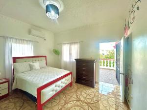 a bedroom with a bed and a dresser and a window at Villa Rosa 3 Habitaciones Balcones Aire Acondicionado Espacio Ideal Para Tu Familia O Grupo in Río San Juan