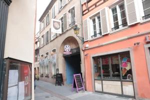 una calle con un edificio con un cartel delante en Les Dentelles - Appartement meublé design Petite France, en Estrasburgo