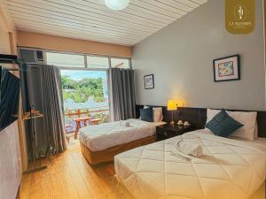 une chambre d'hôtel avec deux lits et un balcon dans l'établissement La Mansion Tagaytay, à Galicias