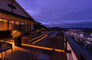 un balcone con sedie e tavoli su un edificio di 尾道倶楽部 a Onomichi