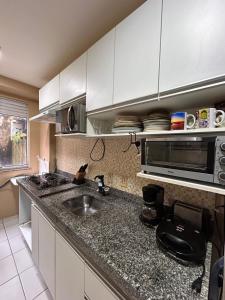 una cocina con fregadero y microondas en Apto Cop30 - Ideal BR - Completo, en Ananindeua
