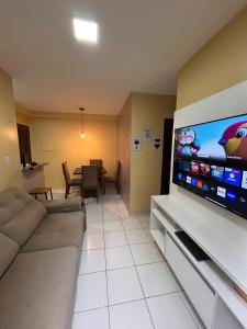 Una sala de estar con un sofá y un televisor de pantalla plana grande. en Apto Cop30 - Ideal BR - Completo, en Ananindeua
