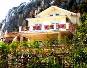 uma casa com caixas de flores no lado de uma montanha em Apartmani Villa Delija Klek em Klek