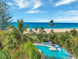 - une piscine bordée de palmiers et une plage dans l'établissement Royal Palm Resort on the Beach, à Gold Coast