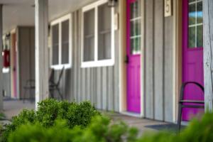 Dos puertas rosas en una casa con un banco. en LumberJill Lodge Room 3, en Balsam Lake