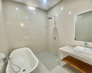 坎古Mahayasa Villa with garden的带白色浴缸和水槽的浴室