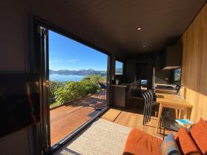 a living room with a view of the ocean at Weka St Eco Cabin in Dunedin