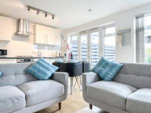a living room with two couches and a kitchen at Palm Villa in Saint Columb Minor +11 photos