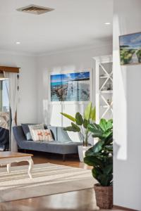 a living room with a blue couch in a room at Large Renovated Home with Ocean Views for Family Fun in Peppermint Grove Beach in Capel
