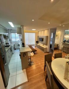 a large kitchen and living room with a table and chairs at 704 B Luxo Centro SP | Brás - Completo + vaga de garagem in Sao Paulo
