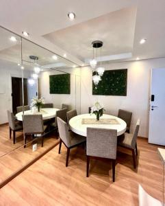 a dining room with two tables and chairs and a mirror at 704 B Luxo Centro SP | Brás - Completo + vaga de garagem in Sao Paulo +6 photos