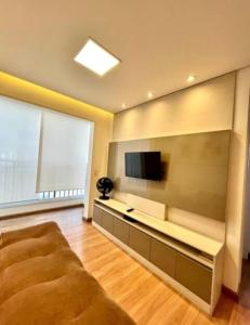a living room with a large couch and a flat screen tv at 704 B Luxo Centro SP | Brás - Completo + vaga de garagem in Sao Paulo