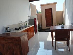 a kitchen with wooden cabinets and a table with chairs at Santika villa ubud in Ubud
