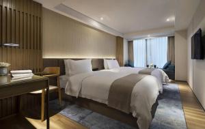 a hotel room with a large bed and a desk at 中濠s酒店福田口岸会展中心店 in Shenzhen