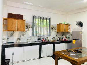 a kitchen with white cabinets and a black counter top at Top Notch by WASA in Kandy