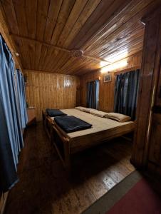 a bedroom with a large bed in a wooden room at Escape Natural Farm Stay - Woodhouse 2 in Kanthalloor +3 photos