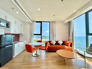 a living room with a couch and a table and chairs at Skyline Hillside Apartment Phu Quoc in Phú Quốc
