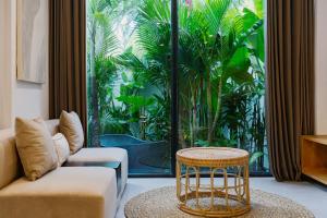 a living room with a couch and a table at Sunny Muse by Betterplace in Canggu