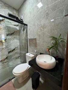 a bathroom with a toilet and a sink and a shower at Chalés Refúgio da Sil 2 in Cavalcante +27 photos