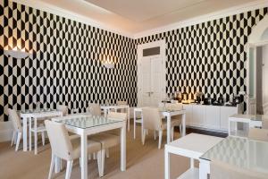 a restaurant with white tables and chairs and a black and white patterned wall at Oporto Comfort Charming Cedofeita - Free Parking in Porto