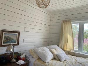 a bedroom with a bed and a window at La petite Maison Baie-Johan-Beetz 