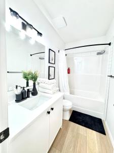 un bagno bianco con vasca e WC di Cozy 2 BR Suite Self check-in I Free Park Pass a YYC