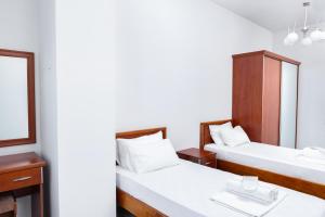 two beds in a room with a mirror at Modern 2-Bedroom Stay in Central Yerevan in Yerevan