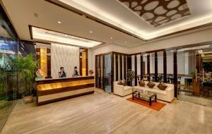 a lobby with couches and a bar in a building at Viceroy Boutique Hotel in Kolkata