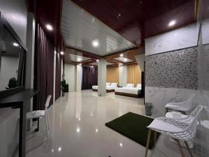 a living room with white chairs and a couch at Serenity Villa Guci in Tuwel