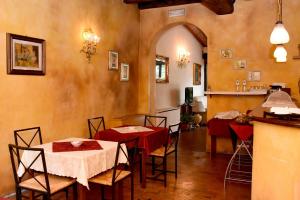 クレーマにあるAlbergo Dimora Storica Antica Hostelleriaの赤いテーブルクロス付きテーブル2台が備わるダイニングルーム