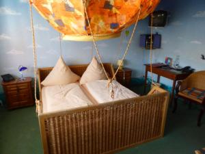 um quarto com uma cama suspensa com almofadas em Gasthaus Storchen Hellas em Haslach im Kinzigtal
