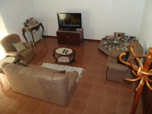 a living room with two couches and a tv at Tropical Fruit Garden in Velas