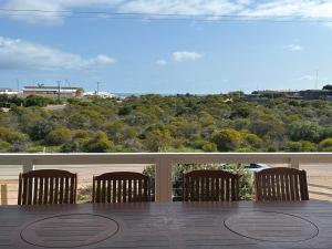 a deck with chairs and a view of a city at Mood Beach House - Moonta Bay in Port Moonta
