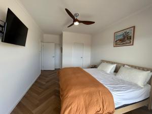 a bedroom with a bed with a ceiling fan at Mood Beach House - Moonta Bay in Port Moonta