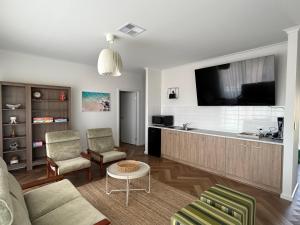 a living room with a couch and a flat screen tv at Mood Beach House - Moonta Bay in Port Moonta