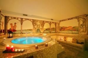 La salle de bains est pourvue d'une grande baignoire avec des bougies. dans l'établissement Hotel Boton D'Or & Wellness, à La Thuile