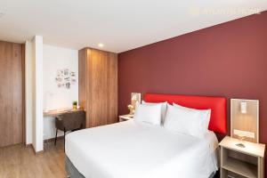 a bedroom with a large bed with a red headboard at Atlantis Home Suites Zona T in Bogotá