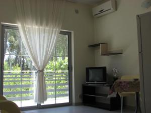 a living room with a tv and a large window at Aparthotel Vila Tufi in Velipojë