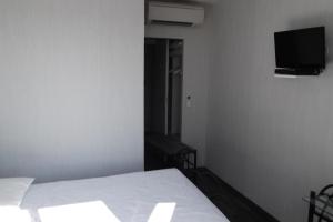 a bedroom with a bed and a flat screen tv at Le Baudilois in Pont-de-Larn